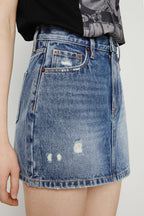 Denim skirt with slight distressing on a plain background