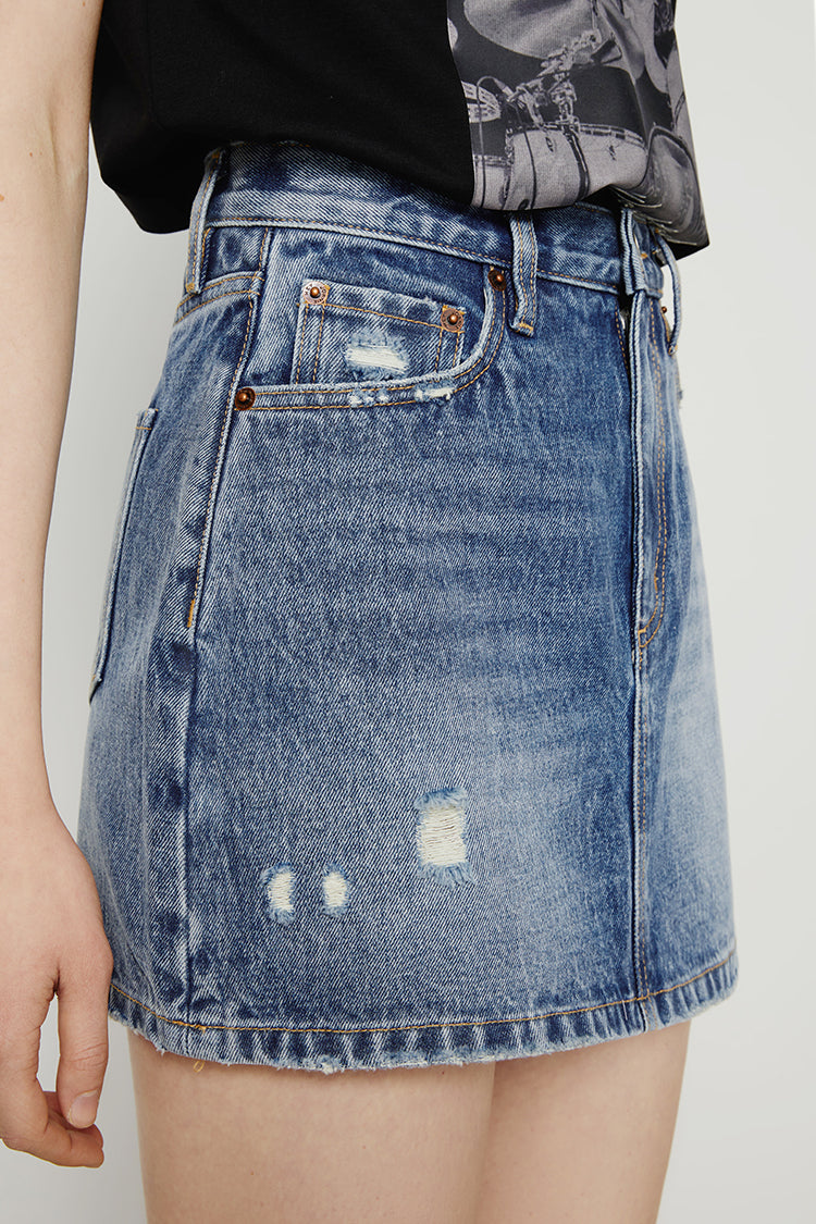 Denim skirt with slight distressing on a plain background