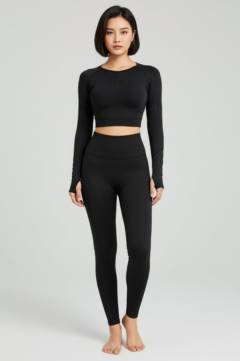 Person wearing a black long-sleeve athletic top and leggings against a gray background