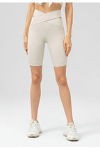 Person wearing beige high-waisted shorts on a grassy background