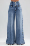Wide-leg jeans with decorative buttons on a blurred city street background