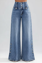 Wide-leg jeans with decorative buttons on a blurred city street background