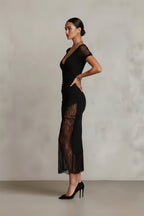 Black lace dress worn by a model against a neutral background