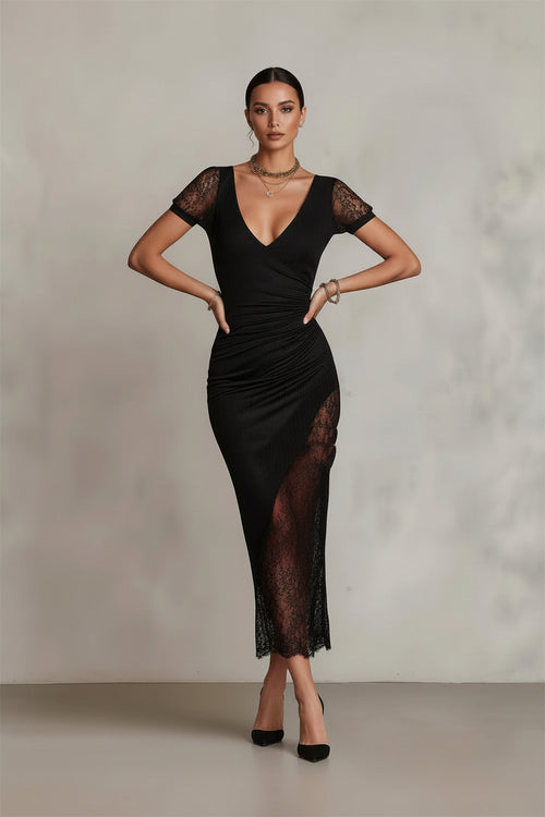 Woman wearing a black dress with lace details against a plain background