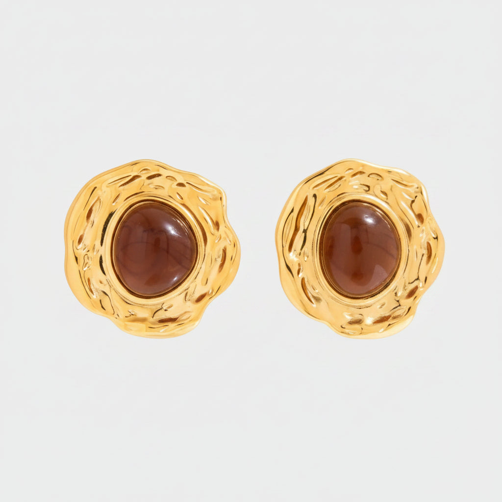 Gold earrings with a brown gemstone on a white background
