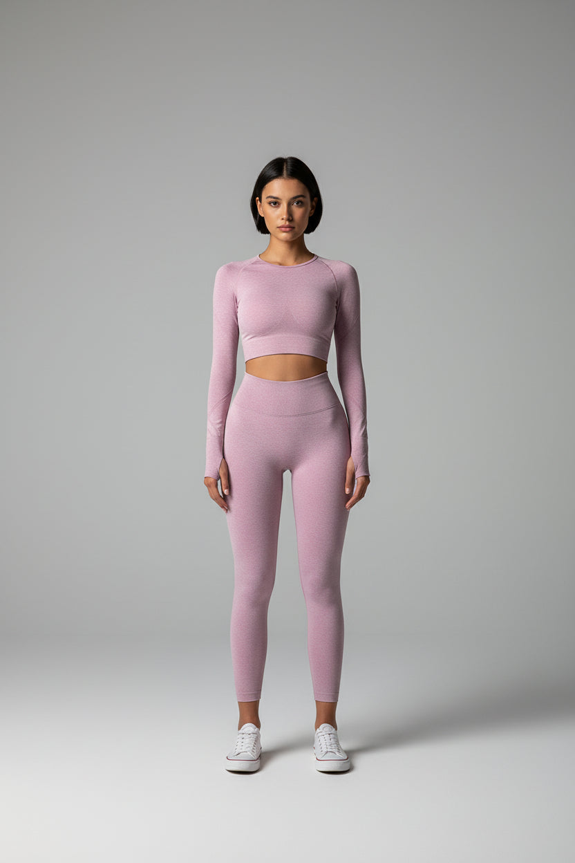 Person wearing a pink athletic outfit standing against a beige wall.