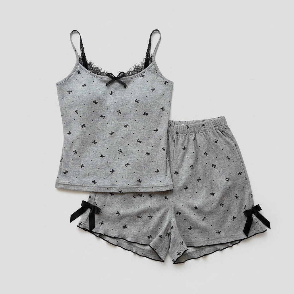 Gray pajama set with black details on a white surface with a cup and paper.