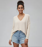 Woman wearing a beige cardigan on a gray background