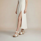 White wedge sandals with cork soles on a neutral background