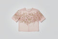 Pink blouse with floral embroidery on a blurred background