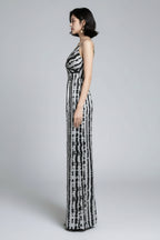 Woman in a black and white patterned dress standing in front of a mirror.