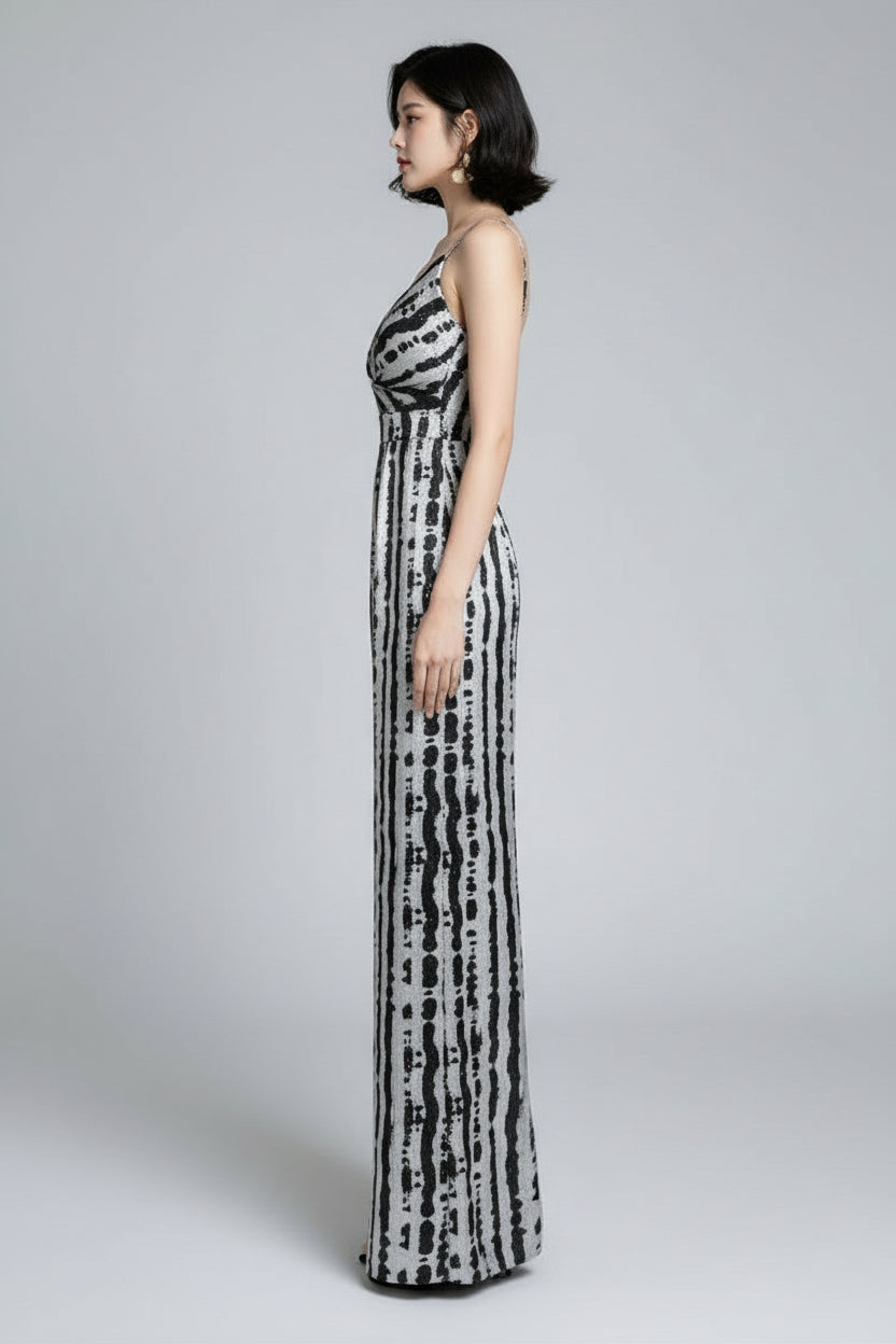 Woman in a black and white patterned dress standing in front of a mirror.