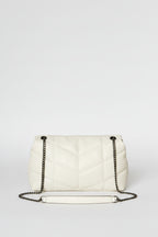 White handbag with chain strap held by a hand against a plain background