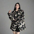 Woman wearing a leopard print coat in an indoor setting