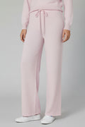 Person wearing light pink pants on a plain background