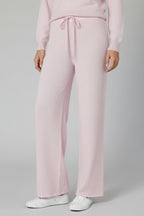 Person wearing light pink pants on a plain background