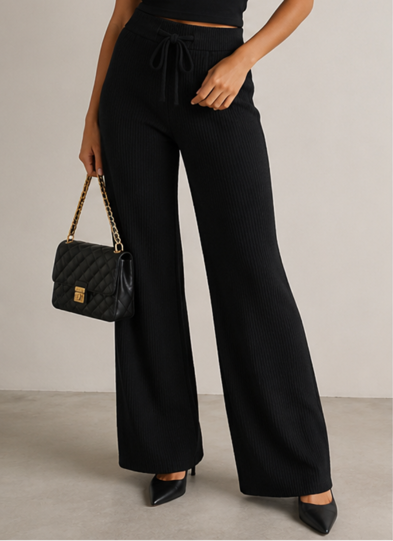 Three women modeling wide-leg drawstring pants in different colorways: black with a black top, brown with a cream top, and gray with a white top, shown in a clean studio setting.