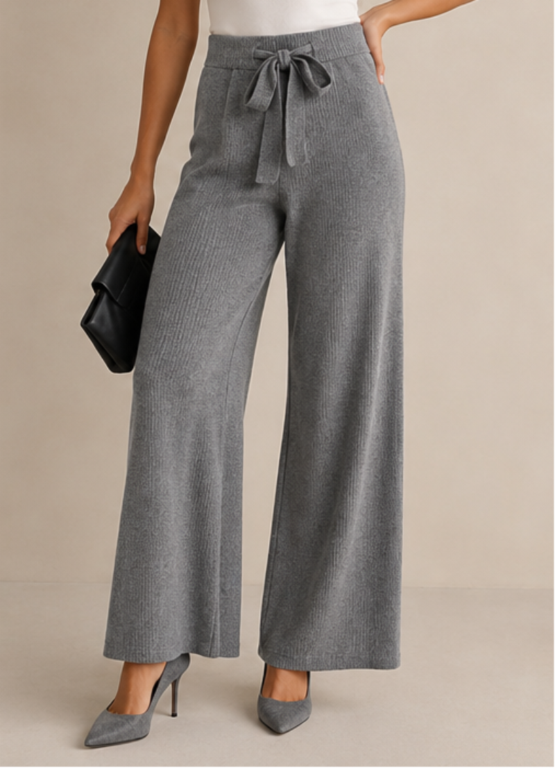 Three women modeling wide-leg drawstring pants in different colorways: black with a black top, brown with a cream top, and gray with a white top, shown in a clean studio setting.