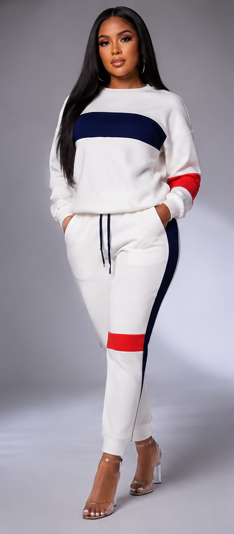A woman modeling a matching white sweatshirt and jogger set in three views: front, back, and side. The outfit features a wide navy blue stripe across the chest, red accents on the upper sleeve and upper thigh, and navy blue side stripes on the joggers.