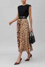 A person wearing a leopard print, big hem skirt with a black top, Accessories such as a belt, handbag, and shoes are also visible.