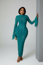 Woman in a teal dress standing in a modern interior setting