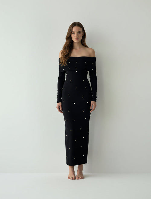 Black off-shoulder dress with pearl embellishments on a plain background