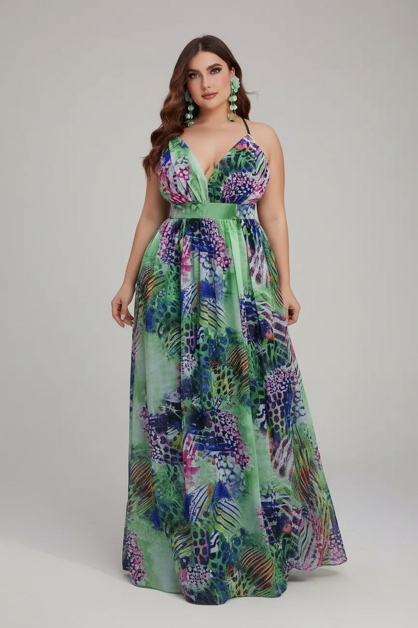 Woman in a colorful dress standing next to pink flowers indoors.