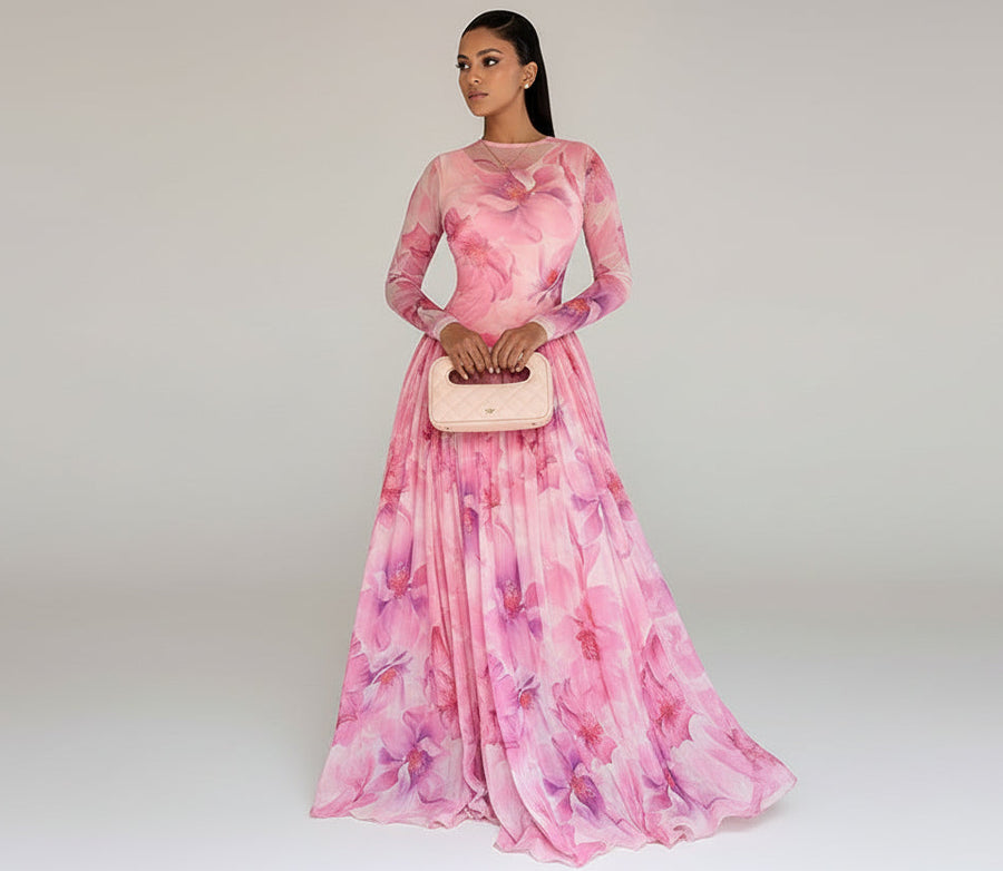 Woman in a pink floral dress standing in a modern indoor setting.