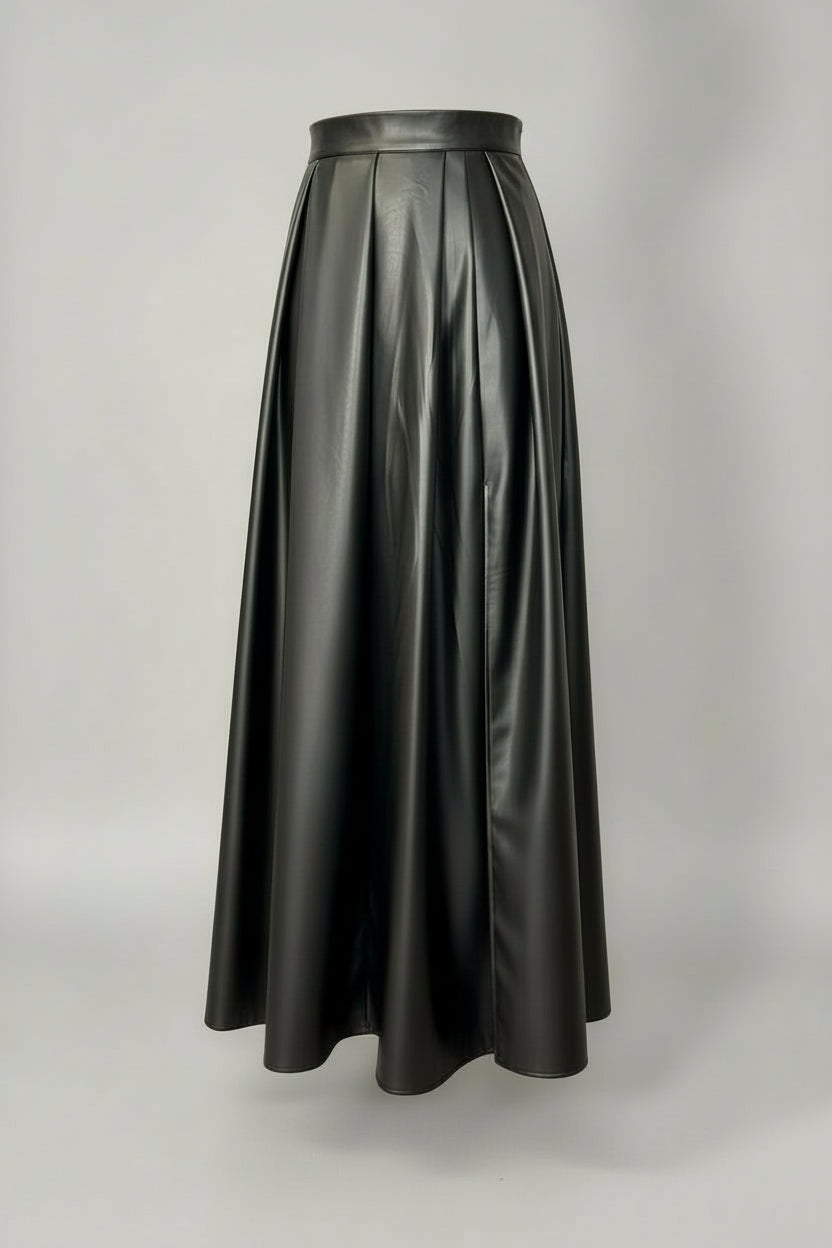 Person wearing a black leather skirt with a red top against a plain background