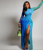 Woman wearing a blue patterned dress with a green handbag against a gray background