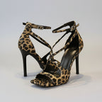 Leopard print high-heeled sandals on a white surface with a neutral background