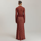 Woman wearing a long burgundy dress against a beige background