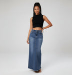 Woman wearing a black crop top and long denim skirt on a white background