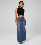 Woman wearing a black crop top and long denim skirt on a white background