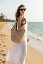 Woven straw bag with black trim on a beige background