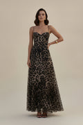 Person wearing a leopard print dress on a wooden dock.