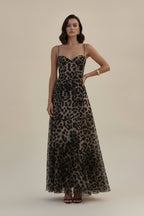 Person wearing a leopard print dress on a wooden dock.