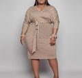 Woman wearing a patterned dress against a plain background