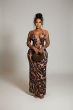 Woman in a leopard print dress standing in a hallway