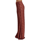 Reddish-brown textured pants on a beige background