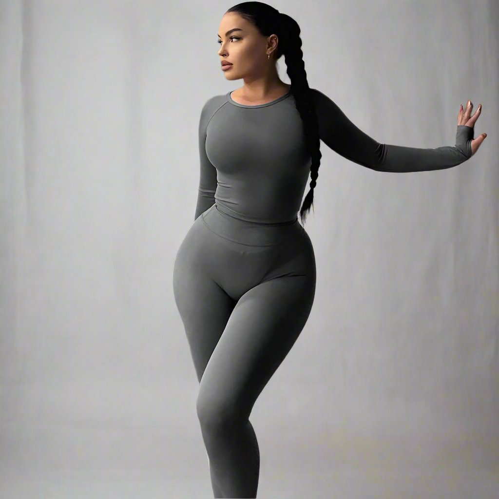 A person wearing long sleeve sports yoga pants in gray, with a crew neck and regular rise.