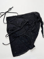 Black glittery fabric with drawstrings on a white background