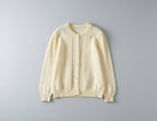 Cream-colored cardigan on a gray background