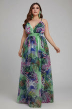 Woman in a colorful floral dress standing in front of pink flowers and a white wall.