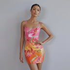 Woman wearing a colorful floral dress against a white paneled wall