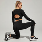 Woman in black athletic outfit stretching outdoors on a sunny day.