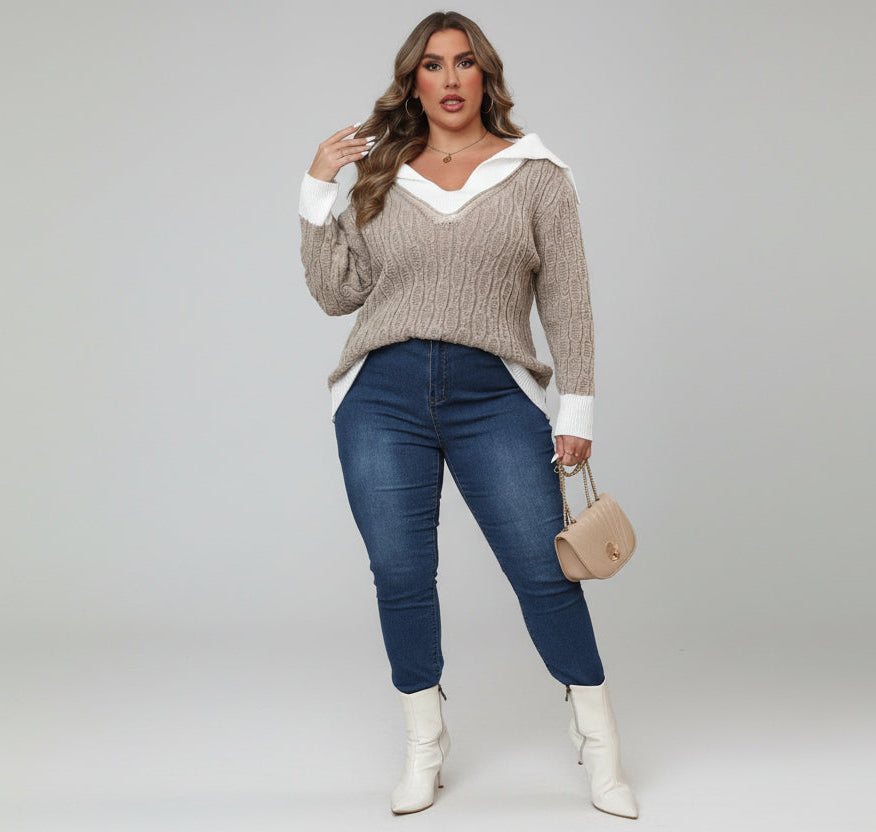 Woman wearing a beige sweater, blue jeans, and white boots in an indoor setting.