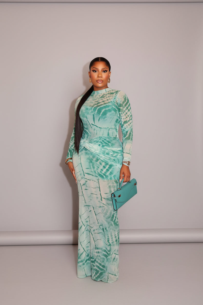 Woman in a patterned dress holding a clutch against a wooden wall.