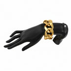 Black mannequin hand wearing a silver chain bracelet on a white background