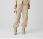 Woman wearing a beige suit with a plain background